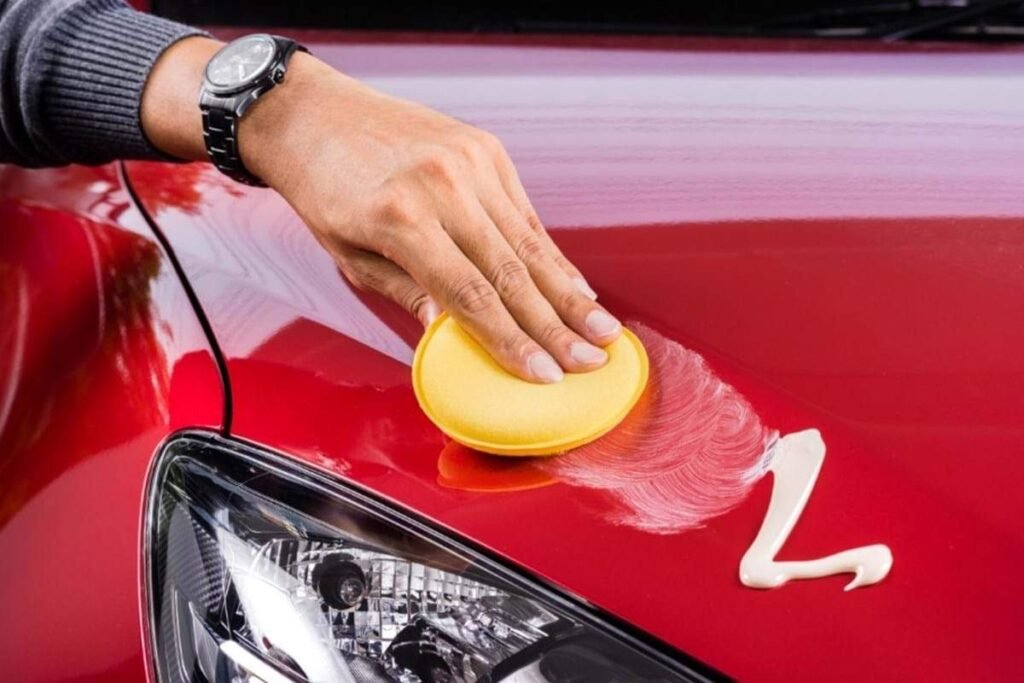 Hand polishing red car hood with foam pad and polish in Frisco TX