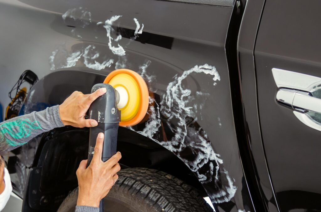 Rotary buffer polishing black SUV fender in Frisco auto detail shop